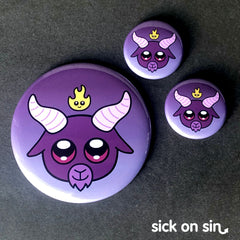 Cute design of of a purple horned goat head with a flame above it. Baby Baphomet is an original design available on pins, magnets, keychains, etc. by Sick On Sin.