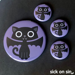 A spooky cute illustration of a black cat with fangs and bat wings. An original design by Sick On Sin available on pins, magnets, keychains, etc.