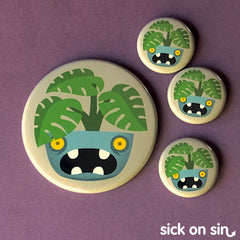 A spooky cute monstera houseplant in a toothy monster plant pot. An original design by Sick On Sin available on pins, magnets, keychains, etc.