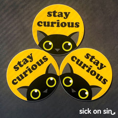 A group of vinyl stickers featuring the original design of a black cat with the phase 'Stay Curious' by Sick On Sin.